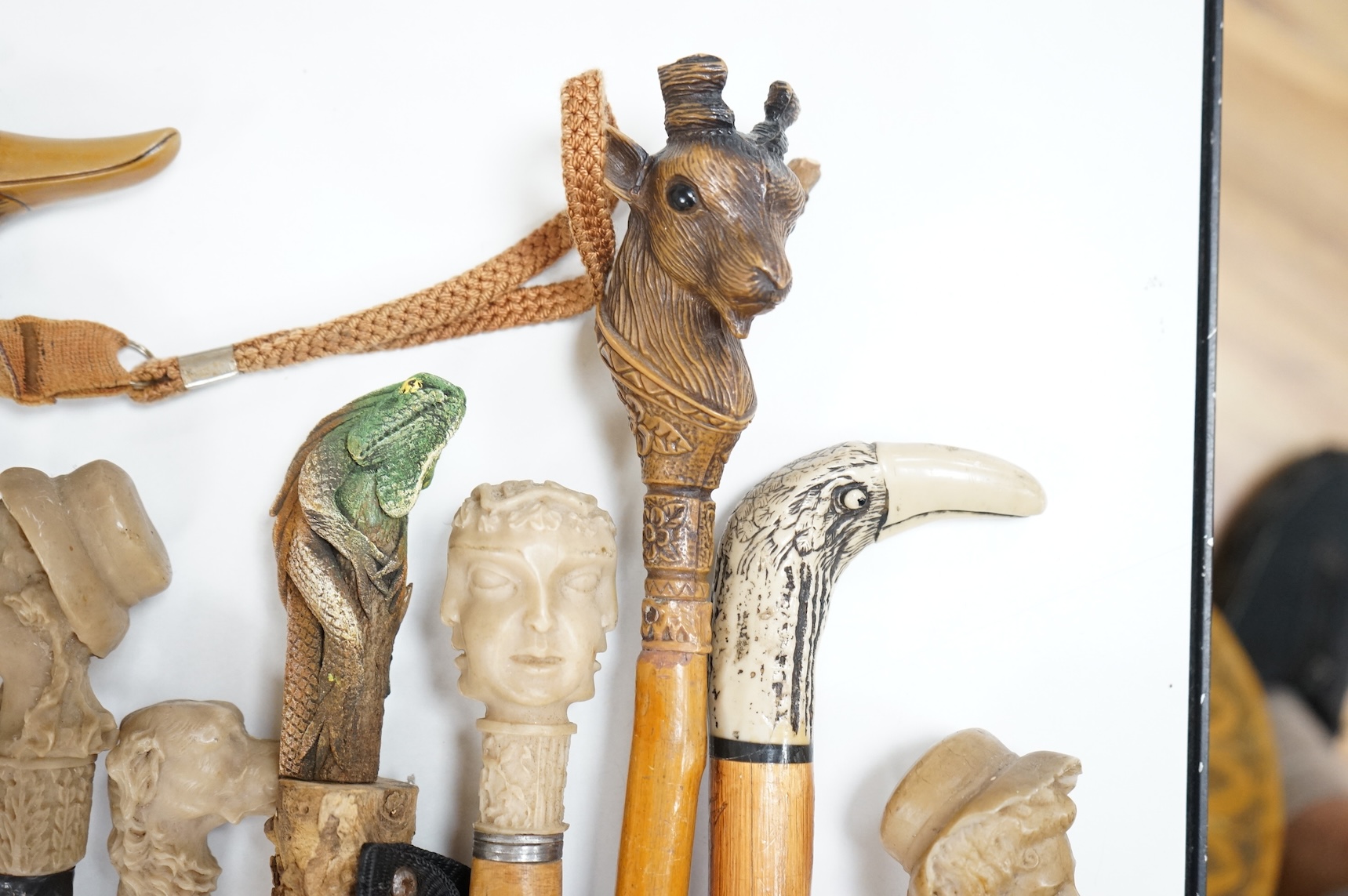 A collection of eight mostly moulded resin mounted walking canes to include one in the form of a lizard, largest 93cm in length